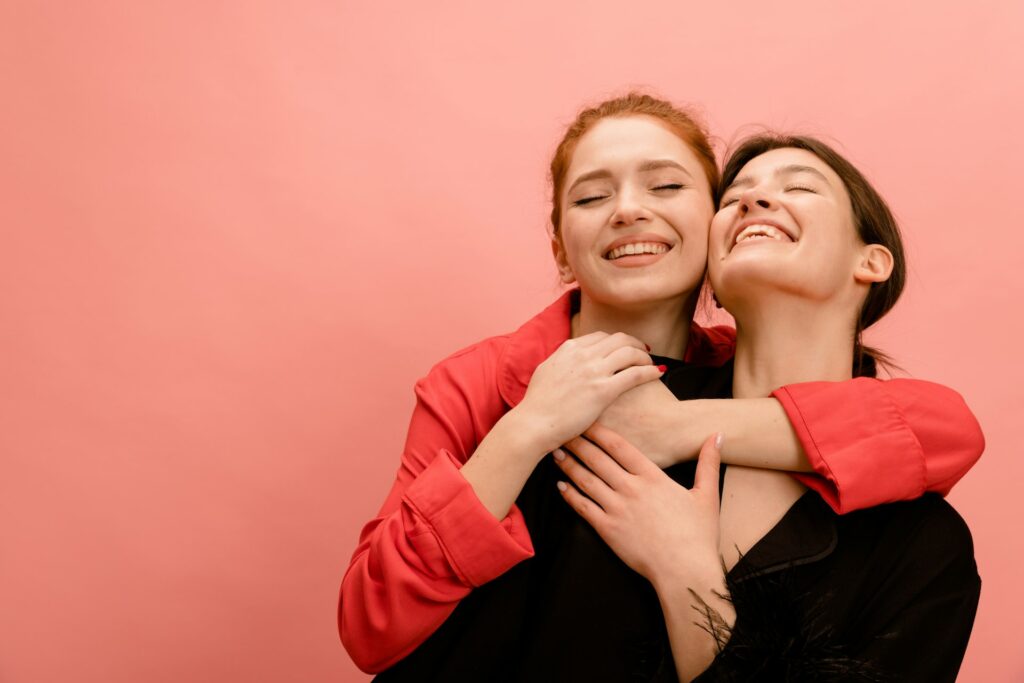 two women hugging each other with their arms around each other
