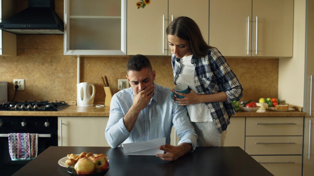 Couple reviewing property documents at the kitchen table